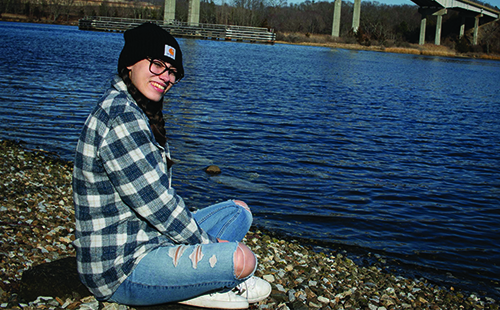 Girl sitting by water